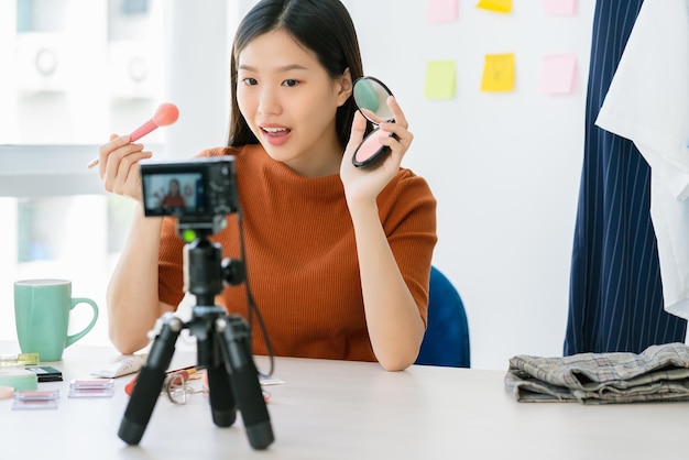 Schöne asiatische Frau mit langem Haar beeinflusst Show-Make-up-Schritt lebt in den sozialen Medien mit Glück und Freude