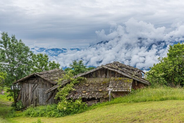 Schöne Aufnahme alter Holzbauernhäuser in den Bergen an einem bewölkten Tag in Südtirol, Italien