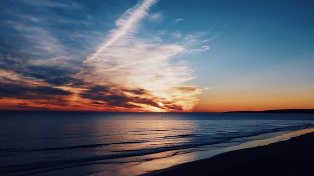 Schöne Aufnahme der Küste und des Meeres mit atemberaubenden Wolken am Himmel im Morgengrauen