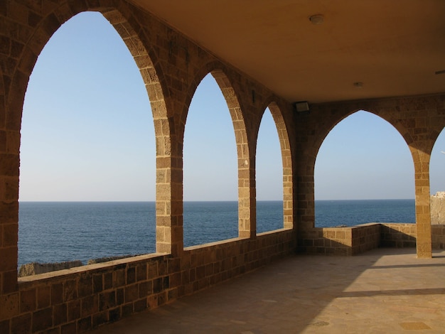 Schöne Aufnahme einer großen Terrasse mit Steinbögen mit Blick auf eine Meereslandschaft