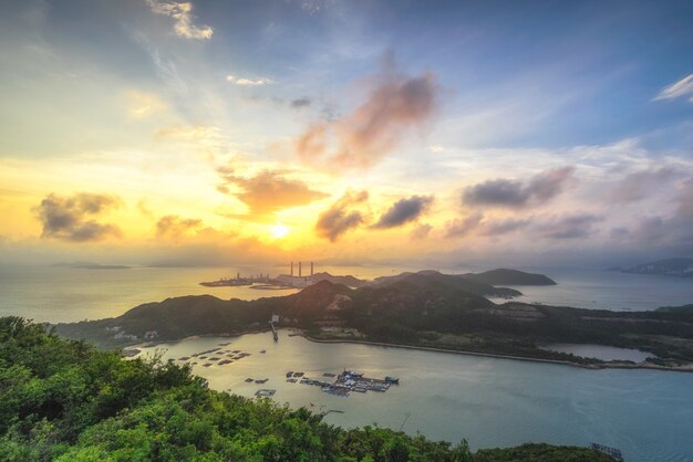 Schöne Aufnahme einer von Meer umgebenen Insel bei bewölktem Himmel bei Sonnenuntergang