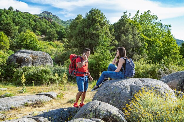 Schöne Aufnahme eines glücklichen Paares, das auf dem Felsen sitzt und die Frische genießt