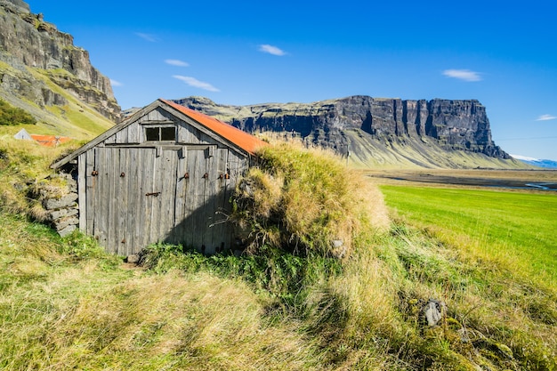 Schöne Aufnahme eines Holzhauses auf einem Feld in Island