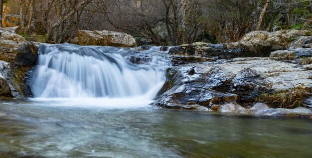 Schöne Aufnahme eines kleinen Wasserfalls, der aus dem Tauwetter kommt