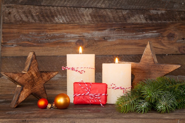 Schöne Aufnahme von Weihnachtsdekorationen und Kerzen, die auf einem hölzernen Hintergrund brennen