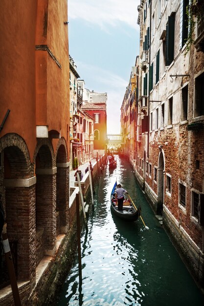 Schöne Aussicht auf den venezianischen Wasserkanal mit Gondolier und Boot. Venedig, Italien.