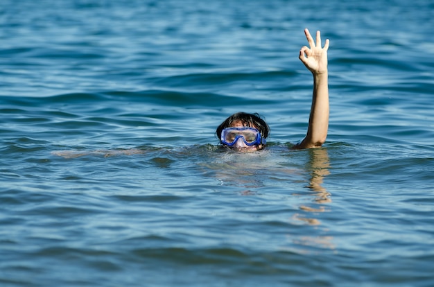 Schöne Aussicht auf eine Frau, die im See mit nur ihrem Kopf und einem Arm aus dem Wasser schwimmt