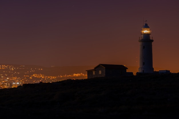 Schöne Aussicht auf einen Leuchtturm und ein Haus auf einem Hügel in der Nacht in Zypern gefangen