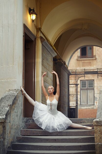 Schöne Ballerina, die nahe einem alten Gebäude tanzt