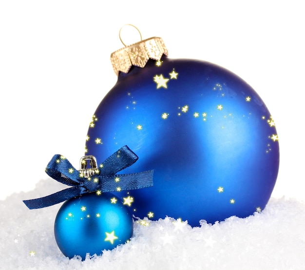 Schöne blaue weihnachtskugeln auf schnee, isoliert auf weiß