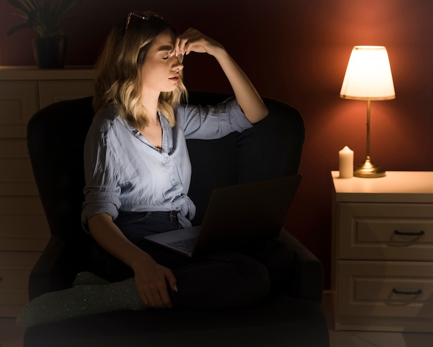 Schöne blonde Frau, die am Laptop arbeitet