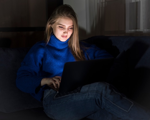 Schöne blonde Frau, die am Laptop arbeitet