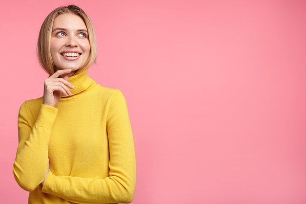 Schöne blonde Frau mit gelbem Rollkragenpullover