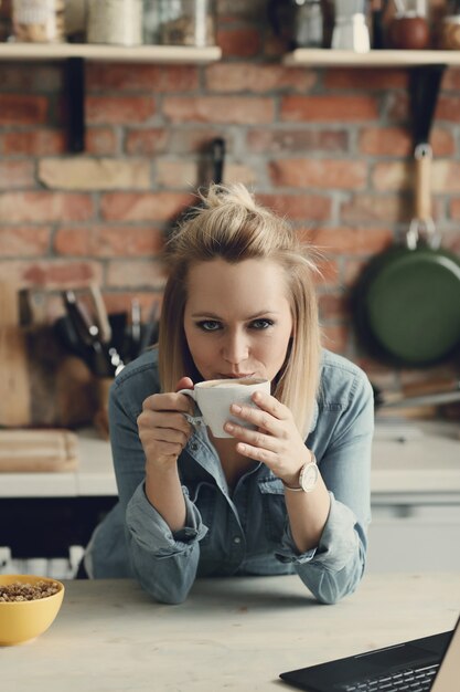 Schöne blonde Frau zu Hause