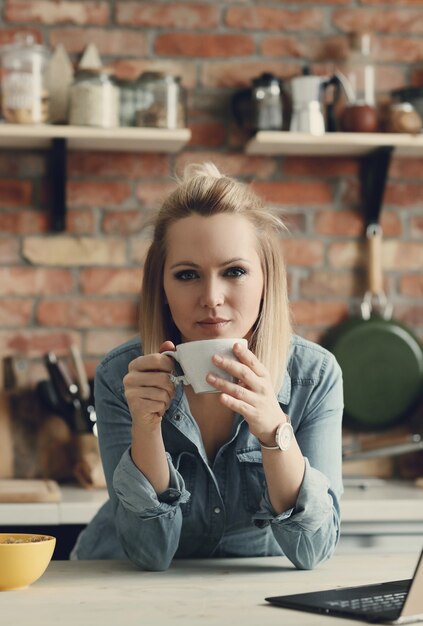 Schöne blonde Frau zu Hause