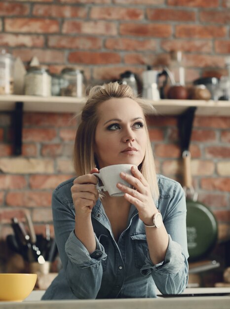 Schöne blonde Frau zu Hause