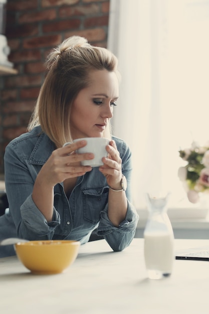 Schöne blonde Frau zu Hause