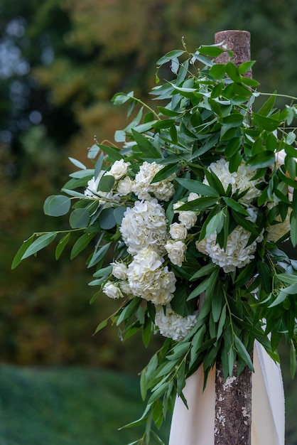 Schöne Blumendekoration mit weißblättrigen Blumen in einem Hochzeitssaal