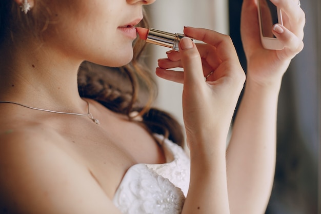 Schöne Braut ihre Lippen malt