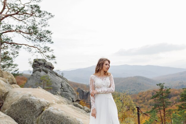 Schöne Braut im weißen Kleid posiert.