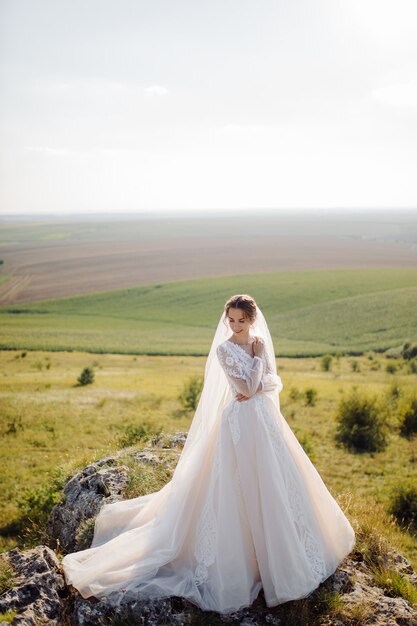 Schöne Braut im weißen Kleid posiert.