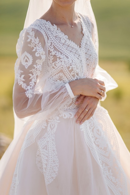 Schöne Braut im weißen Kleid posiert.