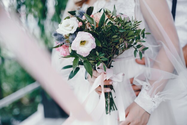 Schöne Braut in einem langen weißen Hochzeitskleid