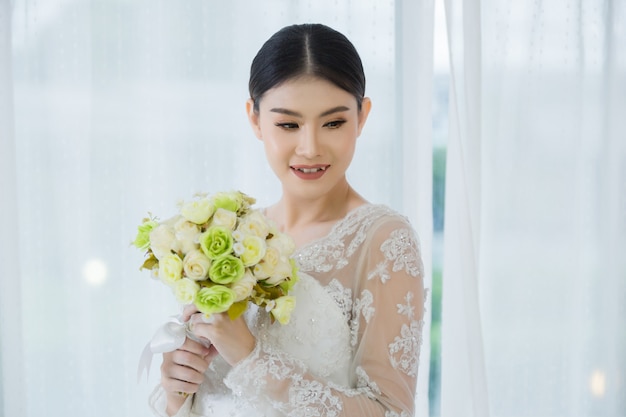 Schöne Braut mit Hochzeit blüht Blumenstrauß