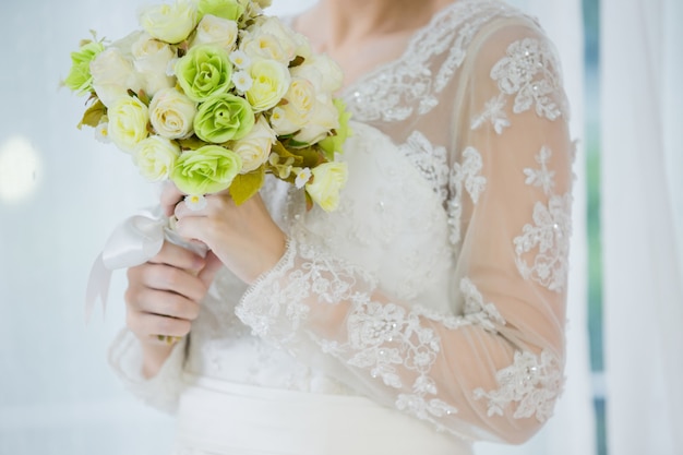 Schöne Braut mit Hochzeit blüht Blumenstrauß