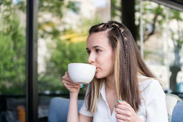 Schöne Dame, die im Restaurant sitzt und Kaffee trinkt