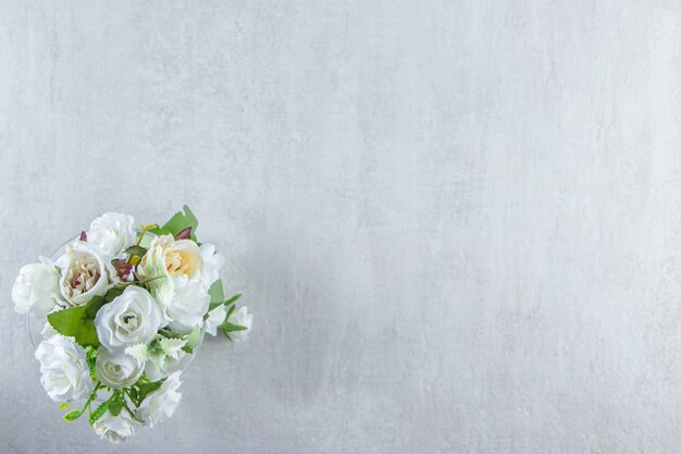 Schöne Duftblumen und Glas, auf dem weißen Tisch.