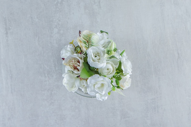 Schöne Duftblumen und Glas, auf dem weißen Tisch.