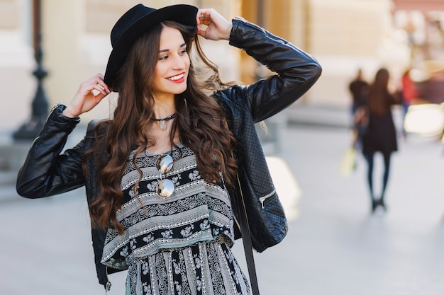 Kostenloses Foto schöne erstaunliche brünette frau mit langer gewellter frisur im frühjahr oder herbst stilvolles städtisches outfit, das auf der straße geht. rote lippen, schlanker körper. street fashion konzept.