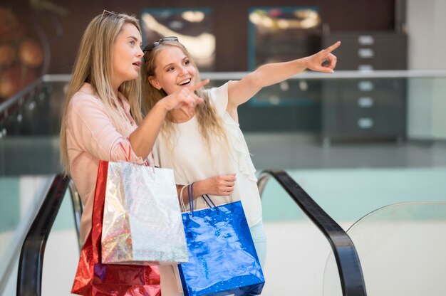 Schöne erwachsene Frauen, die glücklich zusammen einkaufen