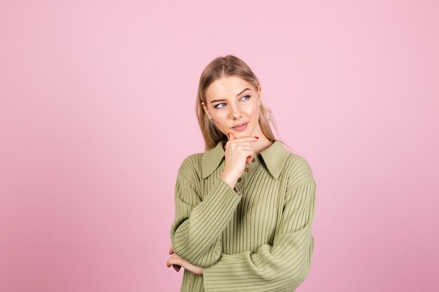 Schöne europäische Frau in beiläufigem Pullover an der rosa Wand