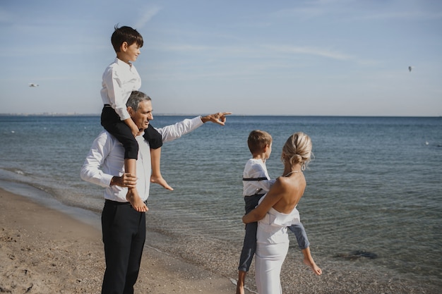 Schöne Familie blickt auf die atemberaubende Landschaft, Eltern und zwei Söhne, am sonnigen Sommertag