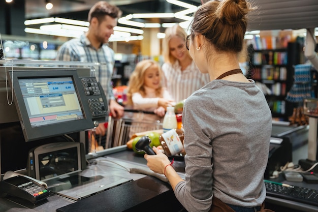 Schöne Familie, die an der Registrierkasse steht