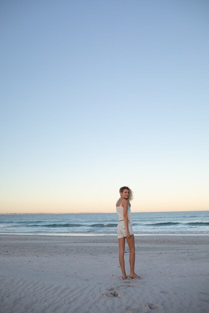 Schöne Frau am Strand stehen