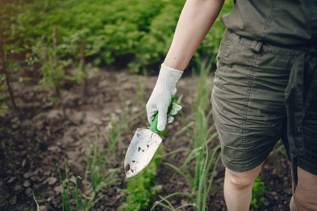 Schöne Frau arbeitet in einem Garten in der Nähe des Hauses