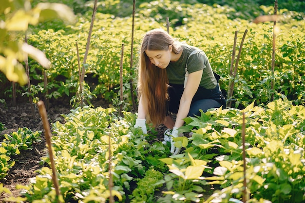 Schöne Frau arbeitet in einem Garten in der Nähe des Hauses