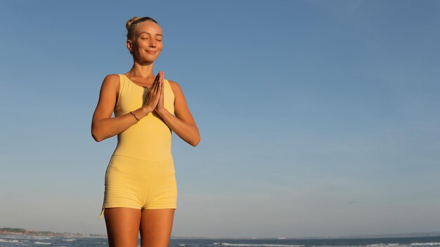 Schöne Frau beim Yoga am Strand