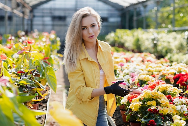 Schöne Frau des Portraits interessiert sich für Blumen