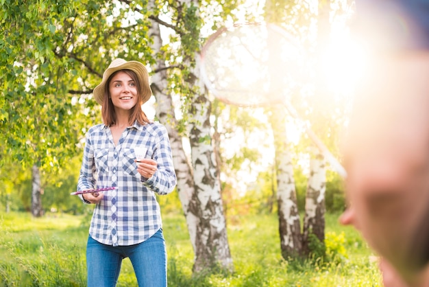 Schöne Frau, die Badminton im Park spielt