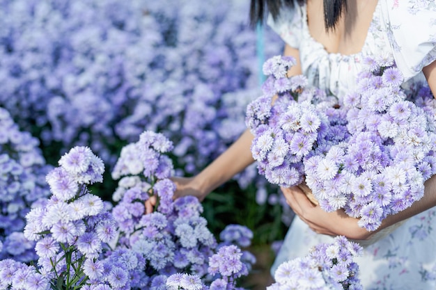 Schöne frau, die blumenfeld genießt