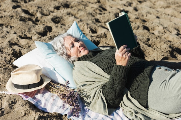 Schöne Frau, die Buch draußen liest