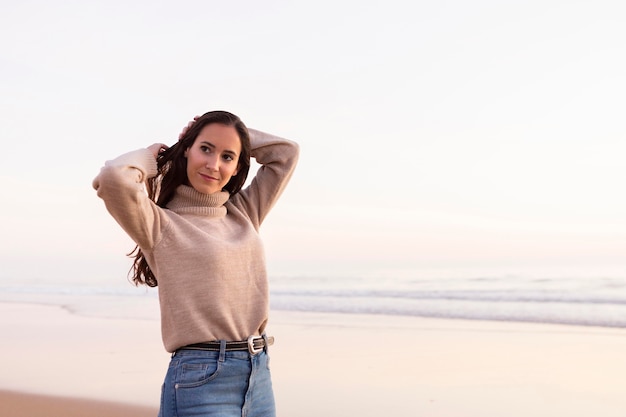 Schöne Frau, die durch den Strand mit Kopienraum aufwirft