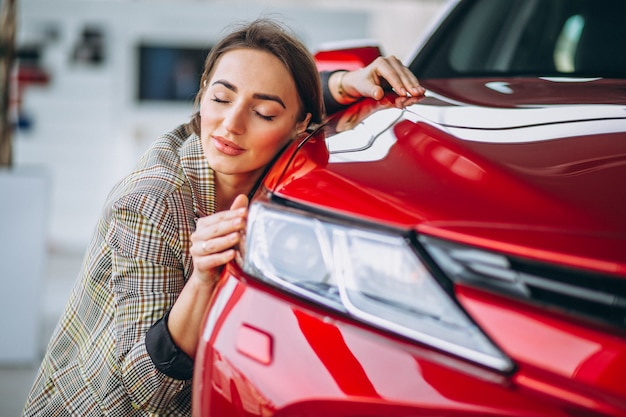 Schöne Frau, die ein Auto umarmt