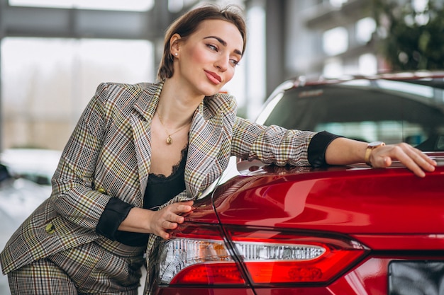 Schöne Frau, die ein Auto umarmt