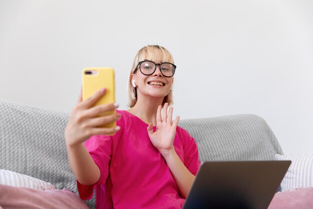 Schöne Frau, die ein Selfie macht, während sie von zu Hause aus arbeitet