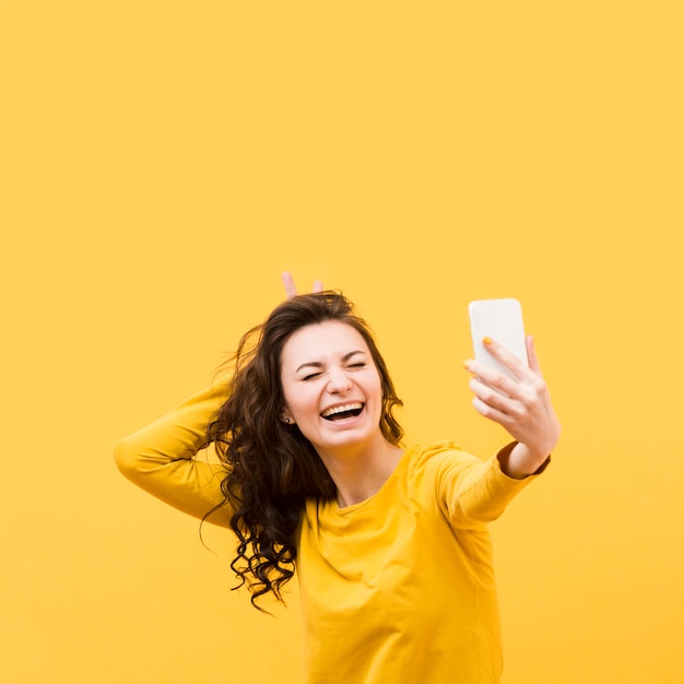 Schöne Frau, die ein Selfie mit Kopienraum nimmt